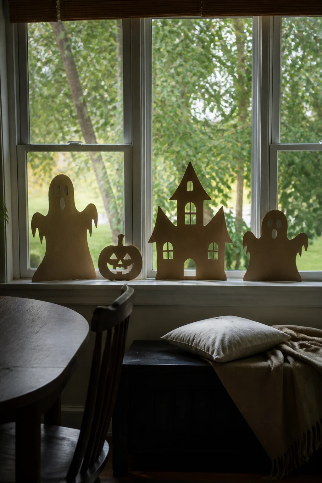 Cardboard silhouettes propped in the sill